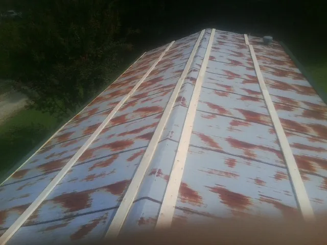 Rusted metal roof panels with new wood purlins before replacement — Storm Damage Roof Repair in Abbottstown by Roofing Brothers