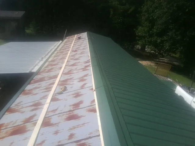 Old rusted panels beside newly installed green metal roofing — Wind Damage Roof Repair by Roofing Brothers in Abbottstown