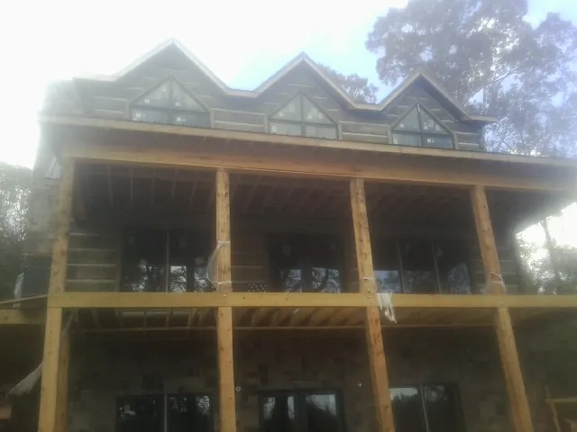 Dormers and porch framing on a large log home under construction — Roof Coating work by our crew in Abbottstown