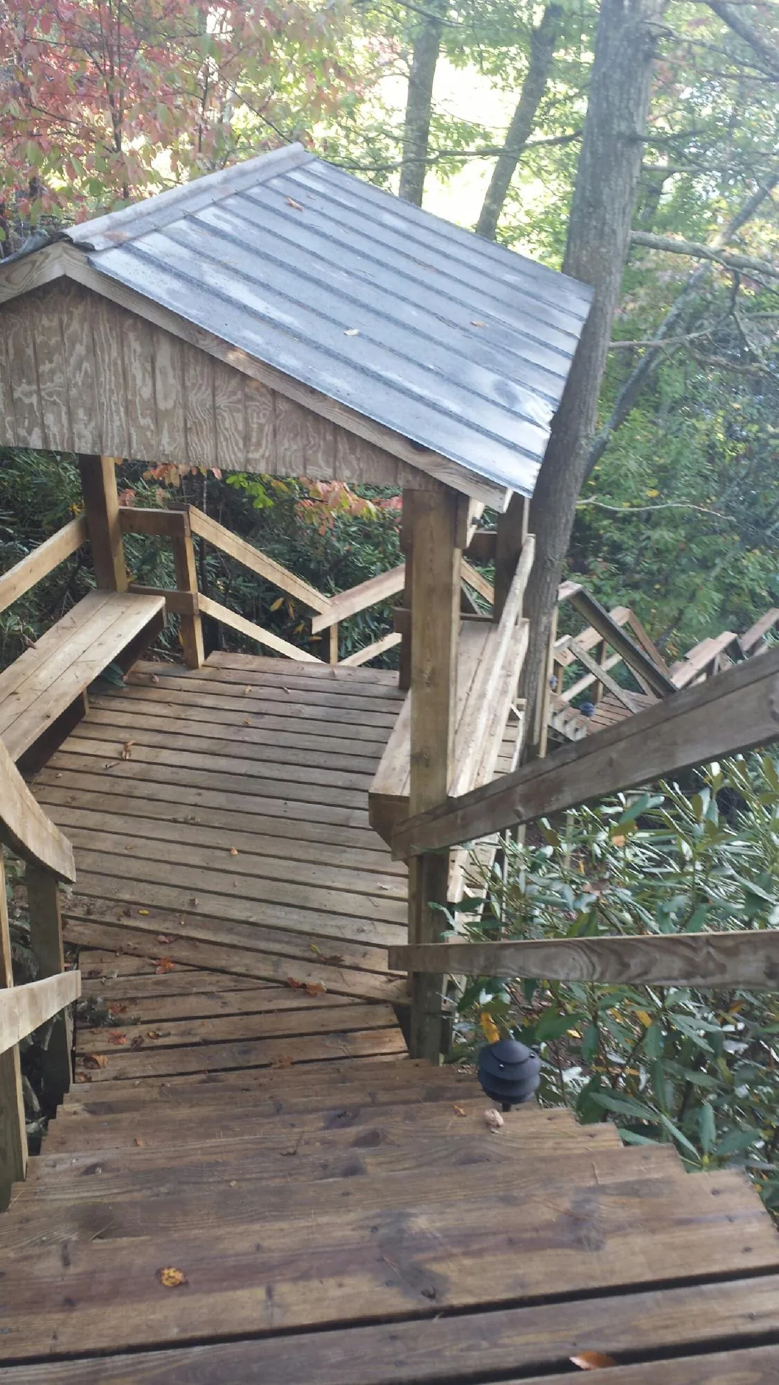 Metal roofed shelter over wooden steps on a wooded walkway — Skylight Repair & Installation work by our crew in Abbottstown