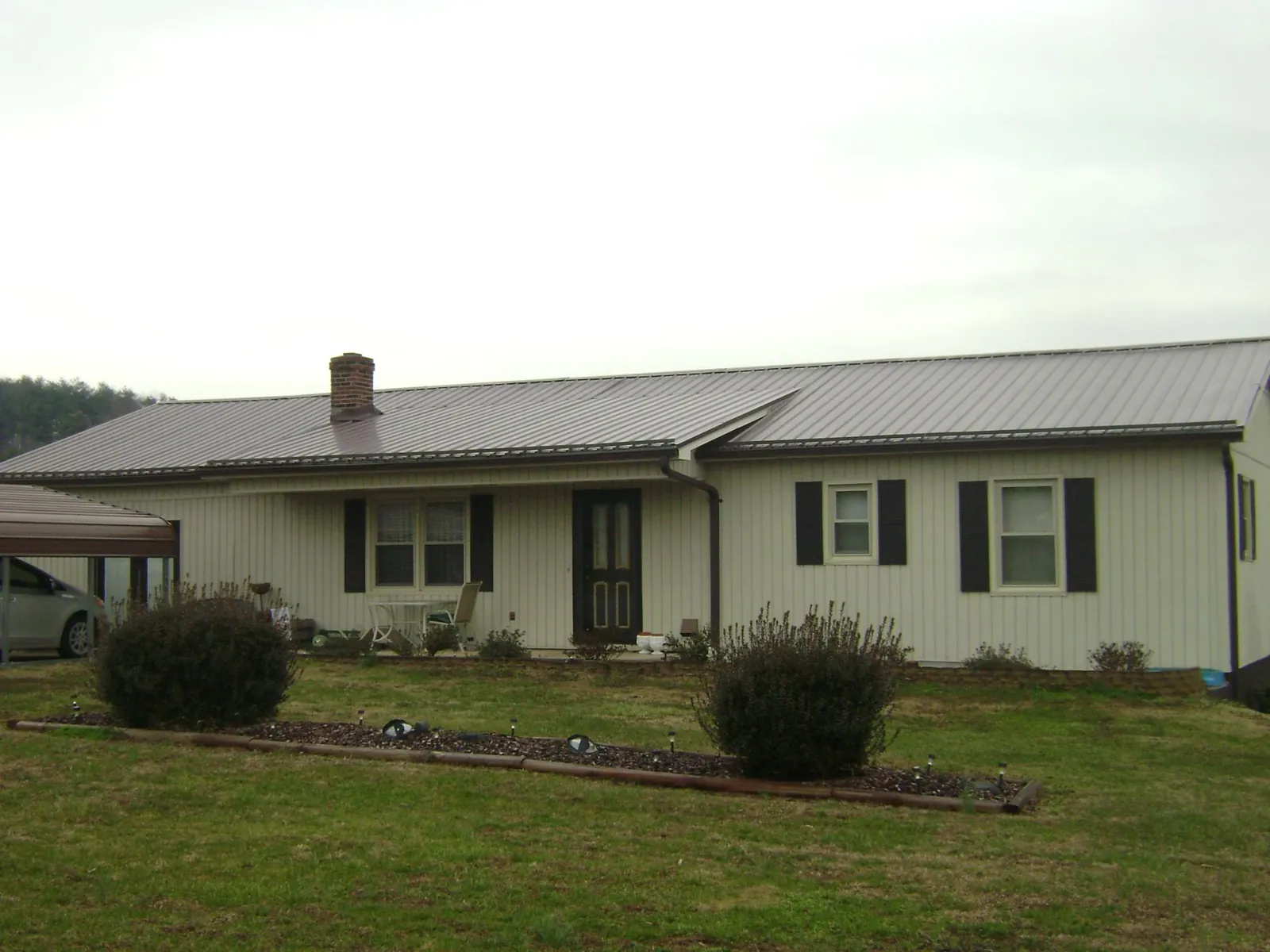 Brown metal roof on a cream sided ranch home with a brick chimney in Abbottstown