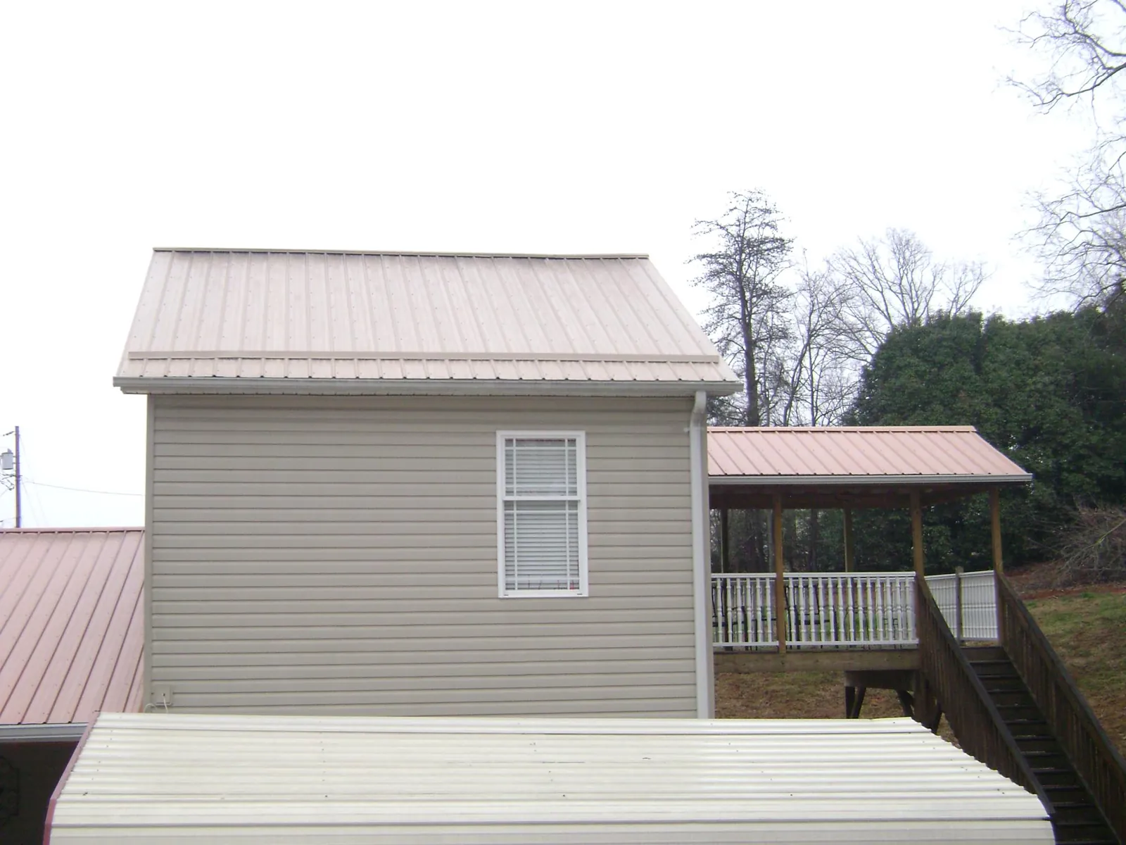 Tan metal roofs on a two story addition and attached porch, from a Roof Replacement job in Abbottstown